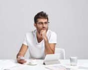 Thoughtful Business Worker Tries Concentrate Holds Mobile Phone As Waits Important Call Scaled